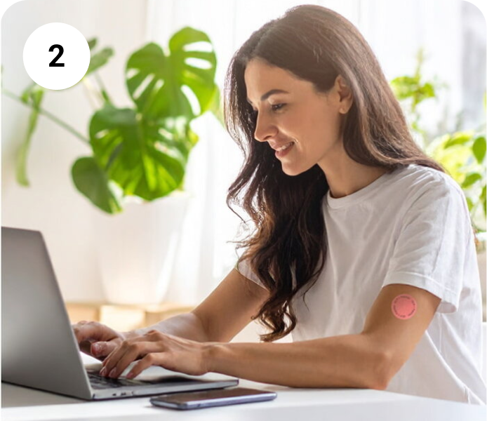 Woman wearing Levia Patch while working at a laptop